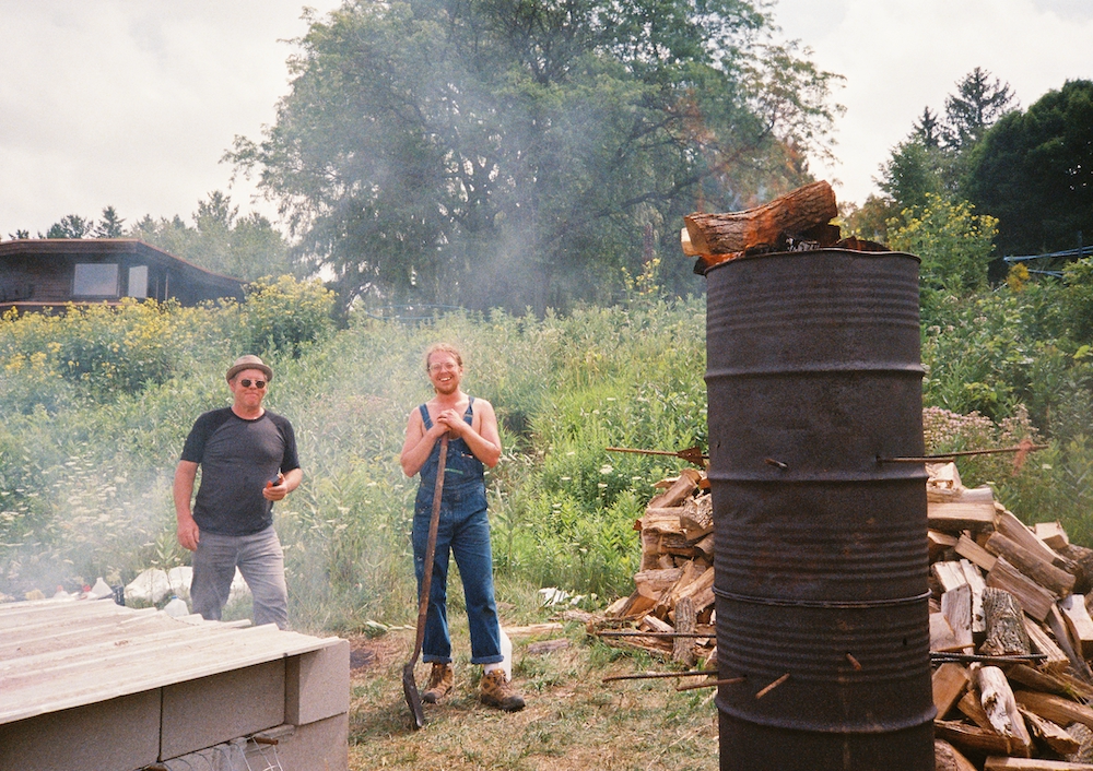 Festival employees stoke wood to create charcoal for a pig roast.