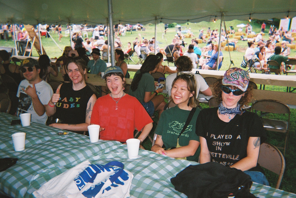 Artists and guests sit in the dining tent.